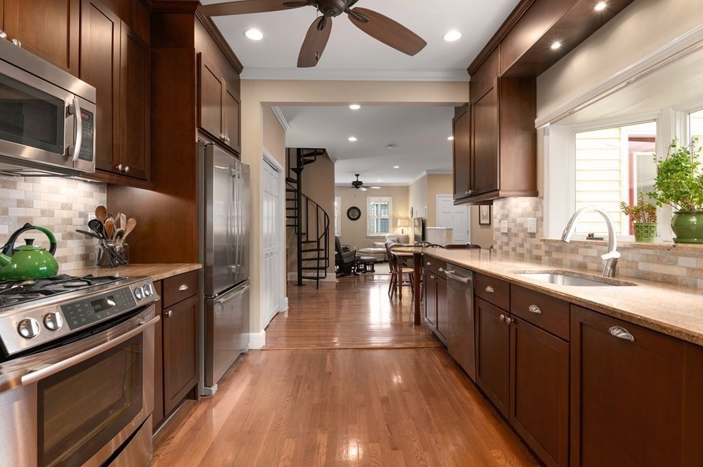 a kitchen with stainless steel appliances granite countertop a sink a stove top oven a counter space and cabinets