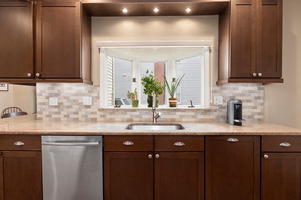 8 Sheafe Street, Unit 1 Boston, MA 02129 - Photo 2 of 19 a kitchen with kitchen island granite countertop a sink stainless steel appliances and cabinets