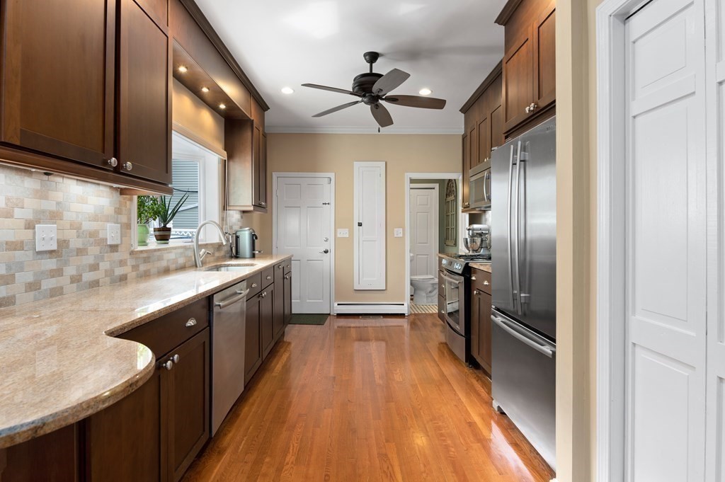 8 Sheafe Street, Unit 1 Boston, MA 02129 - Photo 3 of 19 a kitchen with stainless steel appliances granite countertop a refrigerator a sink dishwasher a stove and white countertops with wooden floor
