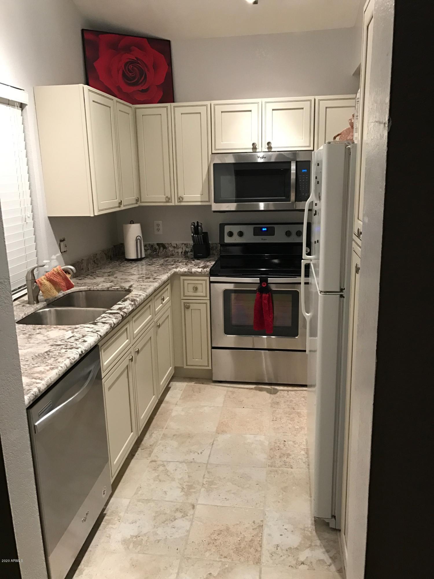 5640 East Bell Road, Unit 1022 Scottsdale, AZ 85254 - Photo 2 of 27 a kitchen with stainless steel appliances granite countertop a refrigerator and a stove