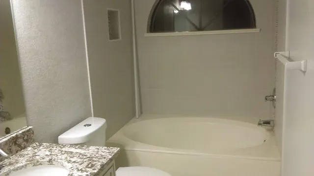 a bath tub sitting next to a toilet and a sink
