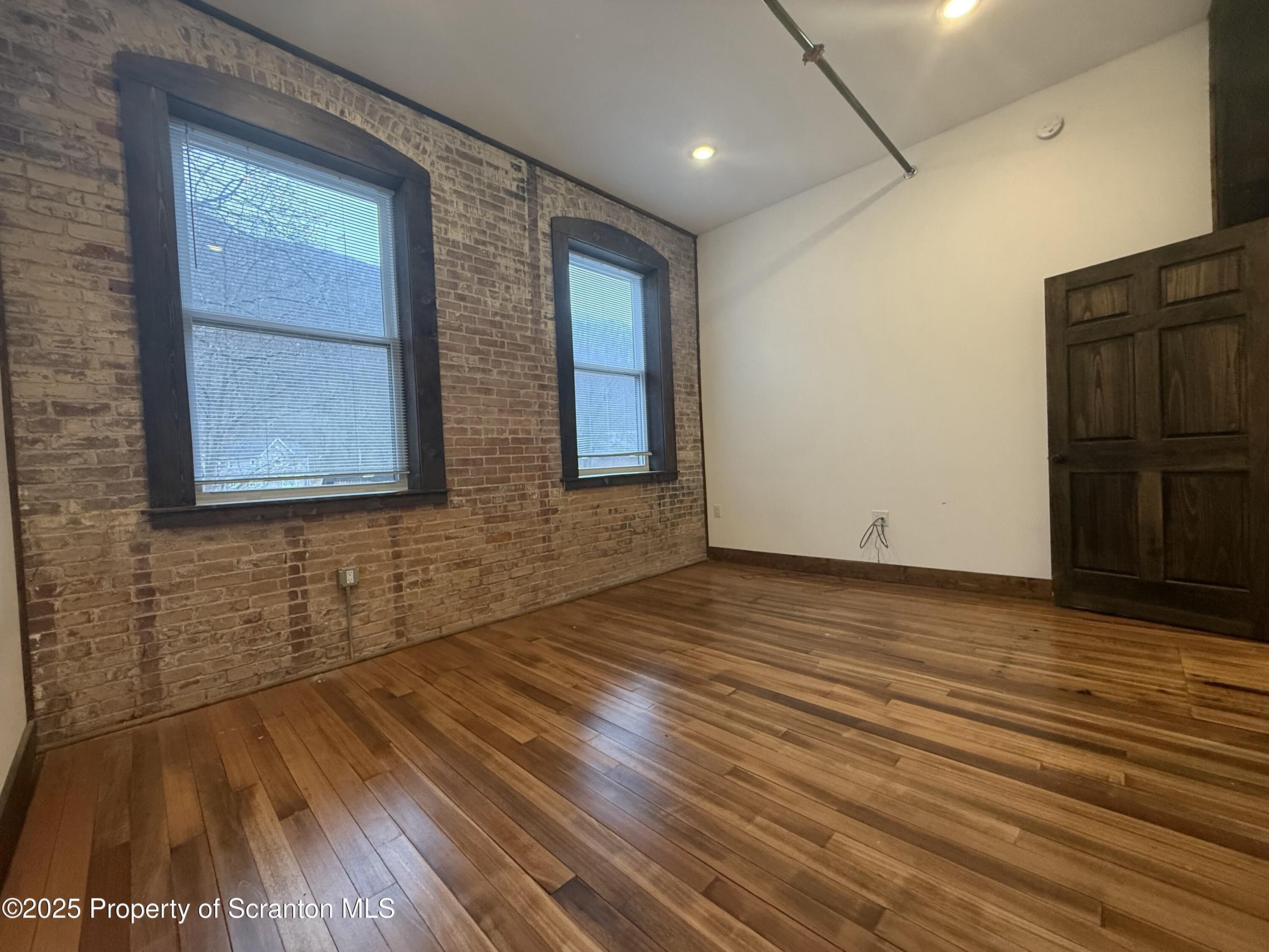 103 Park Street, Unit 1A Honesdale, PA 18431 - Photo 14 of 15 a view of an empty room with wooden floor and a window
