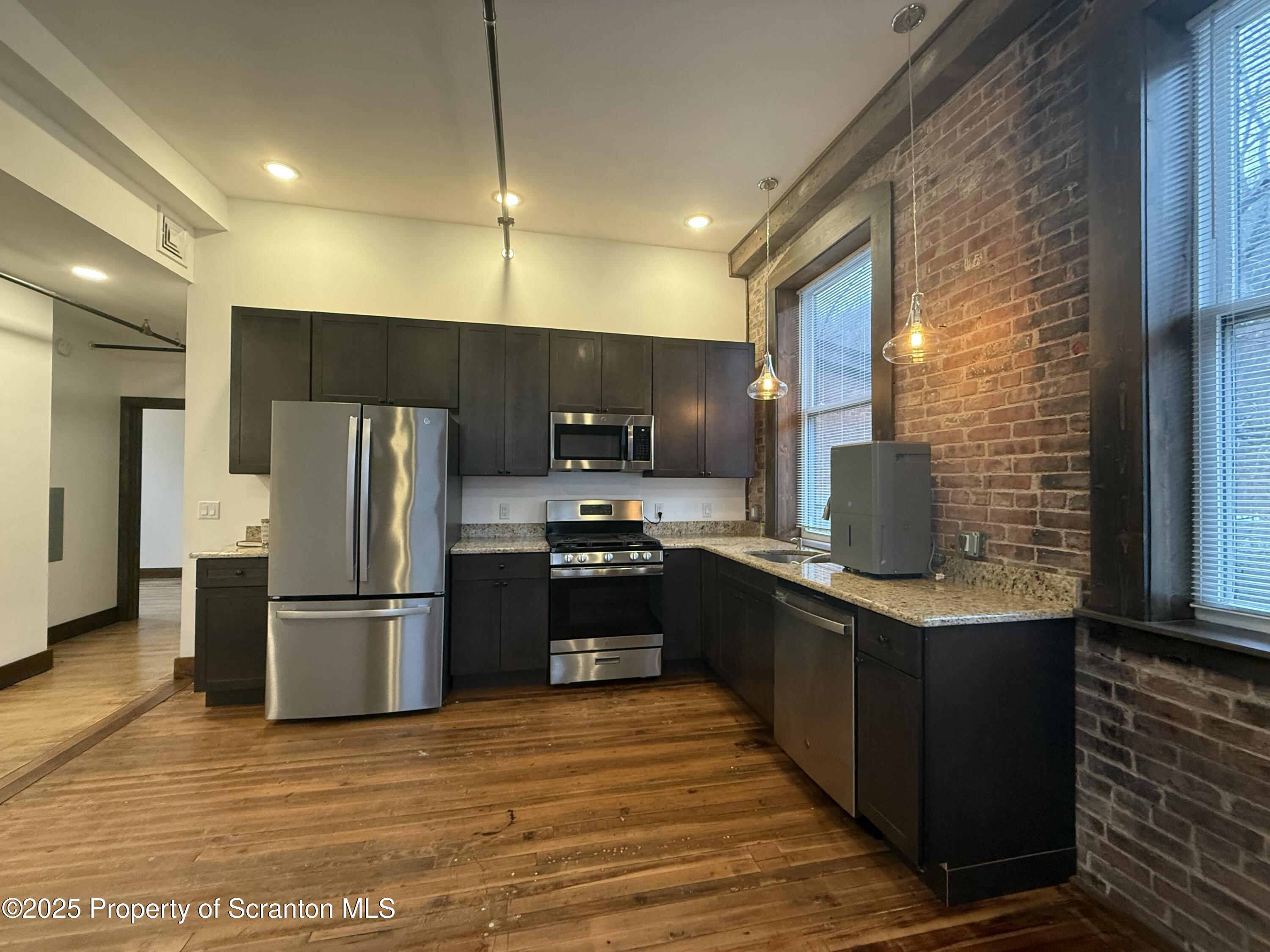 103 Park Street, Unit 1A Honesdale, PA 18431 - Photo 3 of 15 a kitchen with stainless steel appliances wooden floor a refrigerator and a stove