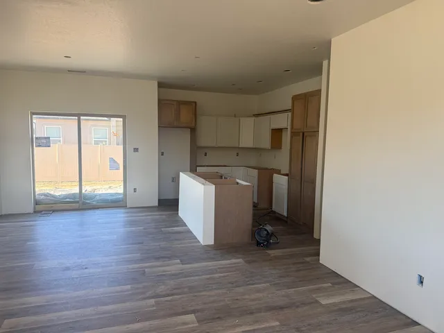 a view of a kitchen with wooden floor and electronic appliances