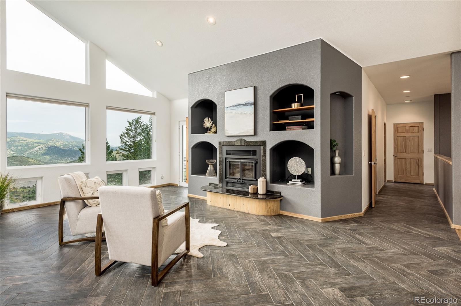 1453 Santa Fe Mountain Road Evergreen, CO 80439 - Photo 11 of 50 a living room with furniture a fireplace and a large window with wooden floor