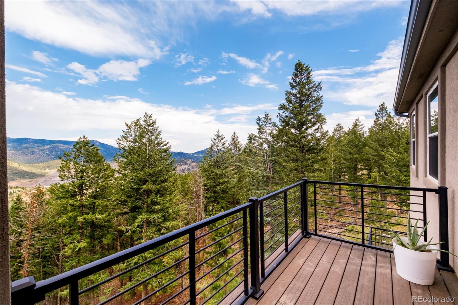 1453 Santa Fe Mountain Road Evergreen, CO 80439 - Photo 12 of 50 a view of a balcony with wooden floor and fence