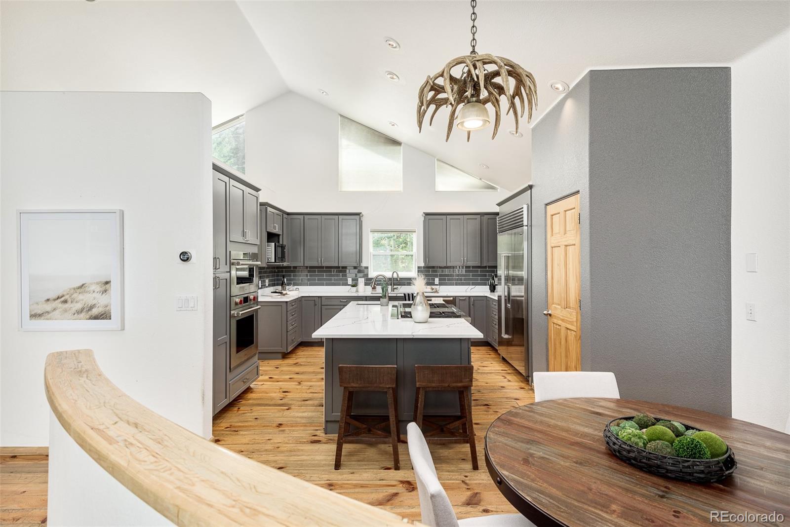 1453 Santa Fe Mountain Road Evergreen, CO 80439 - Photo 17 of 50 a living room with kitchen island furniture and a chandelier