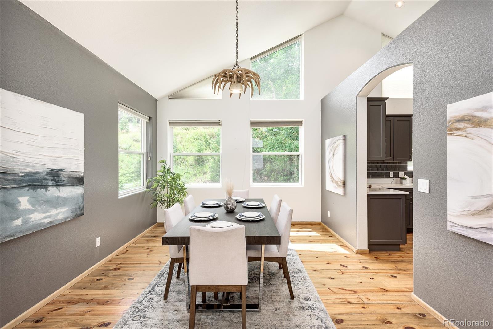 1453 Santa Fe Mountain Road Evergreen, CO 80439 - Photo 20 of 50 a dining room with furniture a chandelier and wooden floor