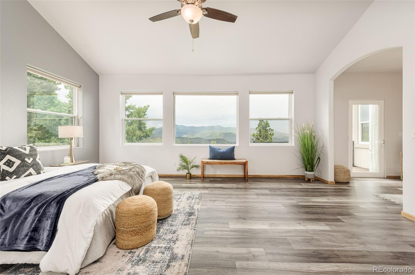 1453 Santa Fe Mountain Road Evergreen, CO 80439 - Photo 23 of 50 a spacious bedroom with a bed and large windows