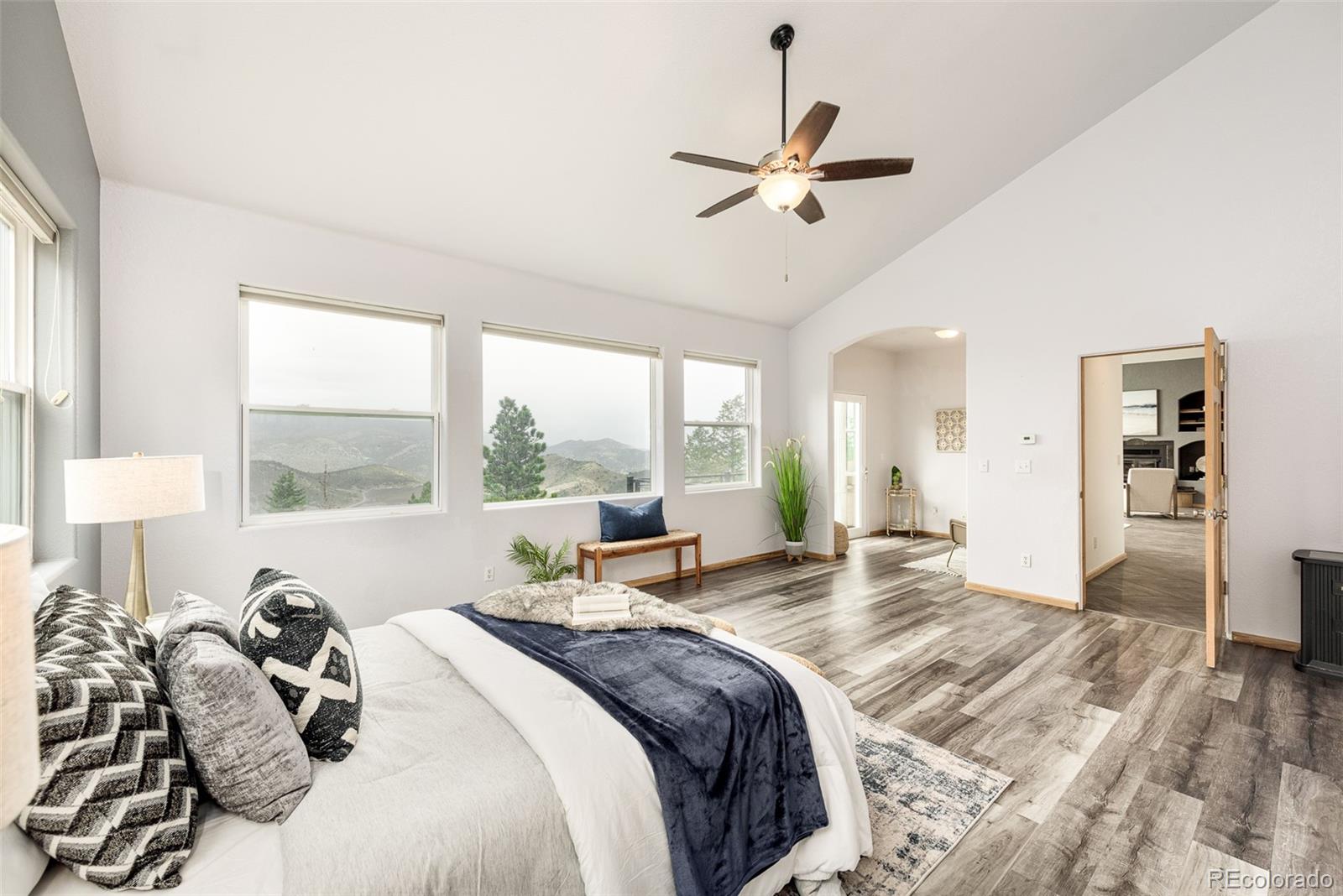 1453 Santa Fe Mountain Road Evergreen, CO 80439 - Photo 24 of 50 a large bedroom with a bed and large windows