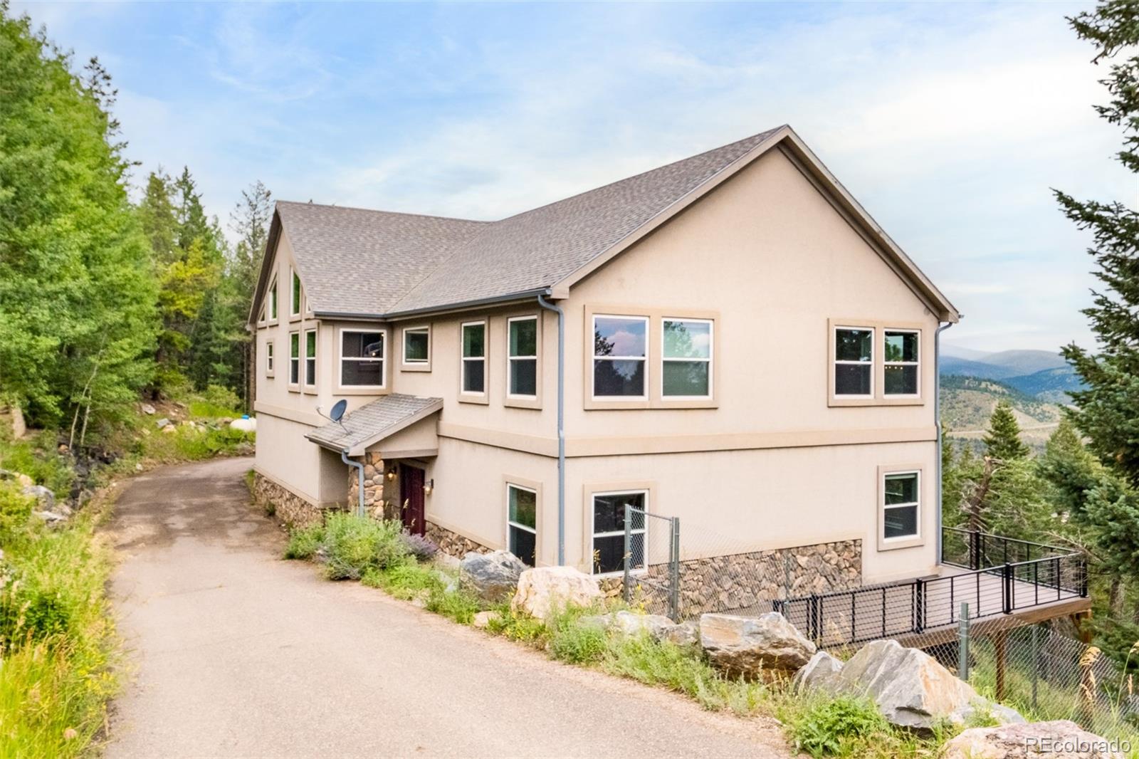 1453 Santa Fe Mountain Road Evergreen, CO 80439 - Photo 3 of 50 a view of a white house with large windows