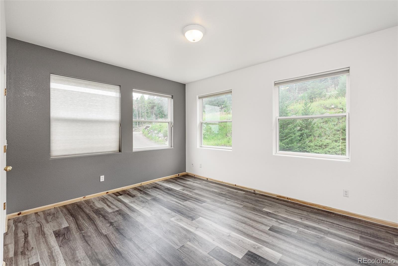 1453 Santa Fe Mountain Road Evergreen, CO 80439 - Photo 31 of 50 a view of an empty room with wooden floor and a window