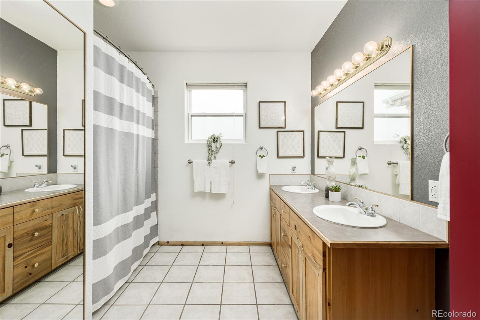 1453 Santa Fe Mountain Road Evergreen, CO 80439 - Photo 32 of 50 a spacious bathroom with a double vanity sink a mirror and a shower