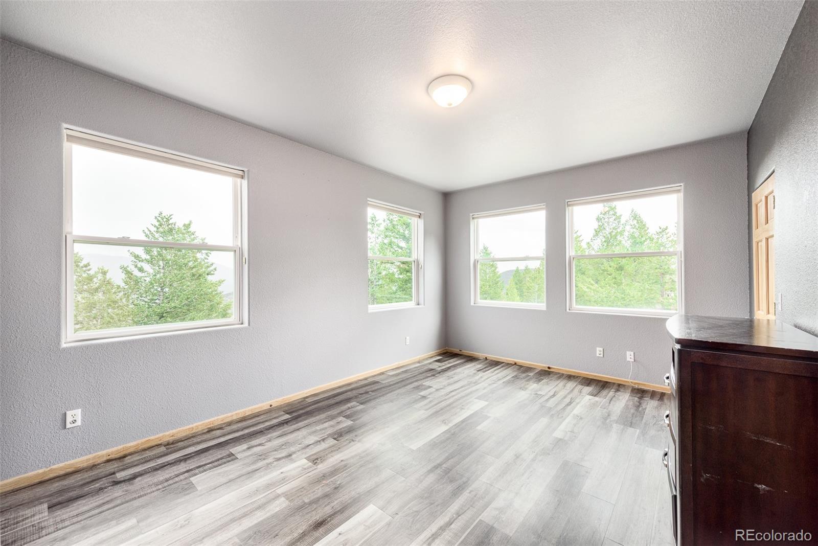 1453 Santa Fe Mountain Road Evergreen, CO 80439 - Photo 33 of 50 a view of an empty room with wooden floor and a window