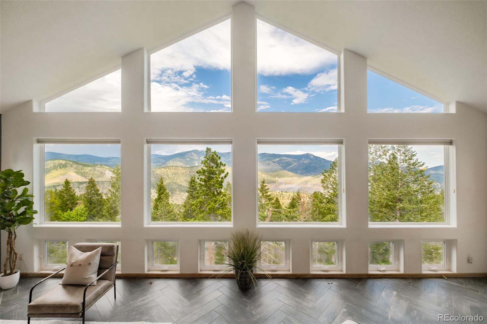 1453 Santa Fe Mountain Road Evergreen, CO 80439 - Photo 8 of 50 a living room with a large window and a floor to ceiling window