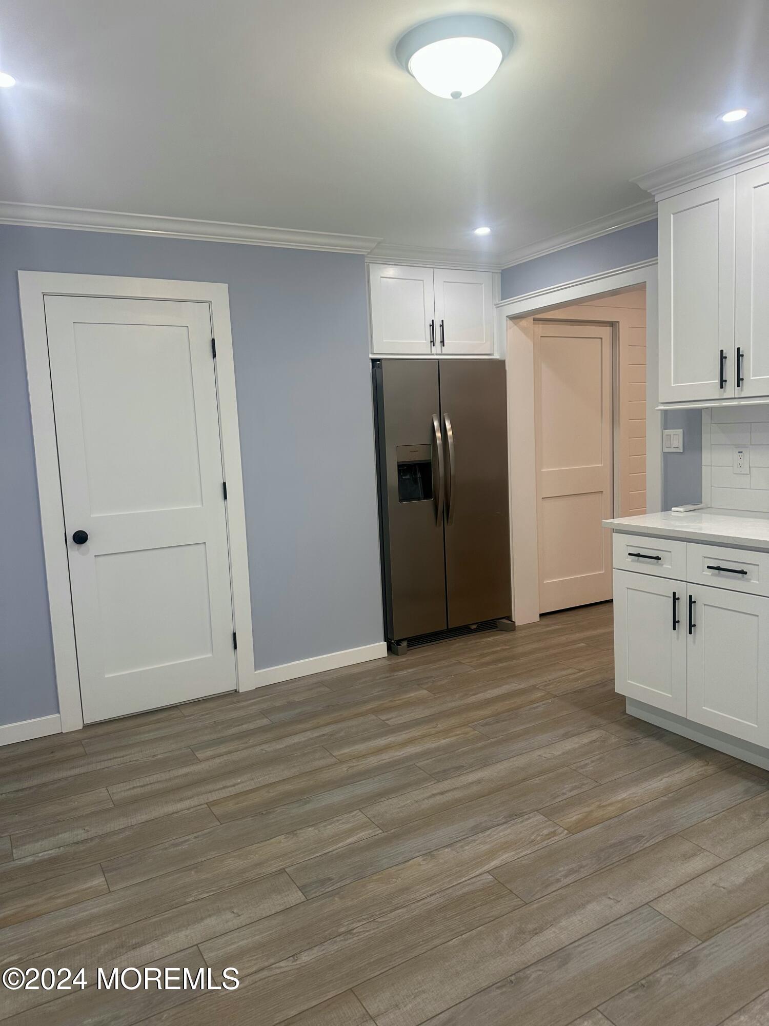 73 Church Street Manasquan, NJ 08736 - Photo 15 of 27 an empty room with wooden floor cabinet and windows