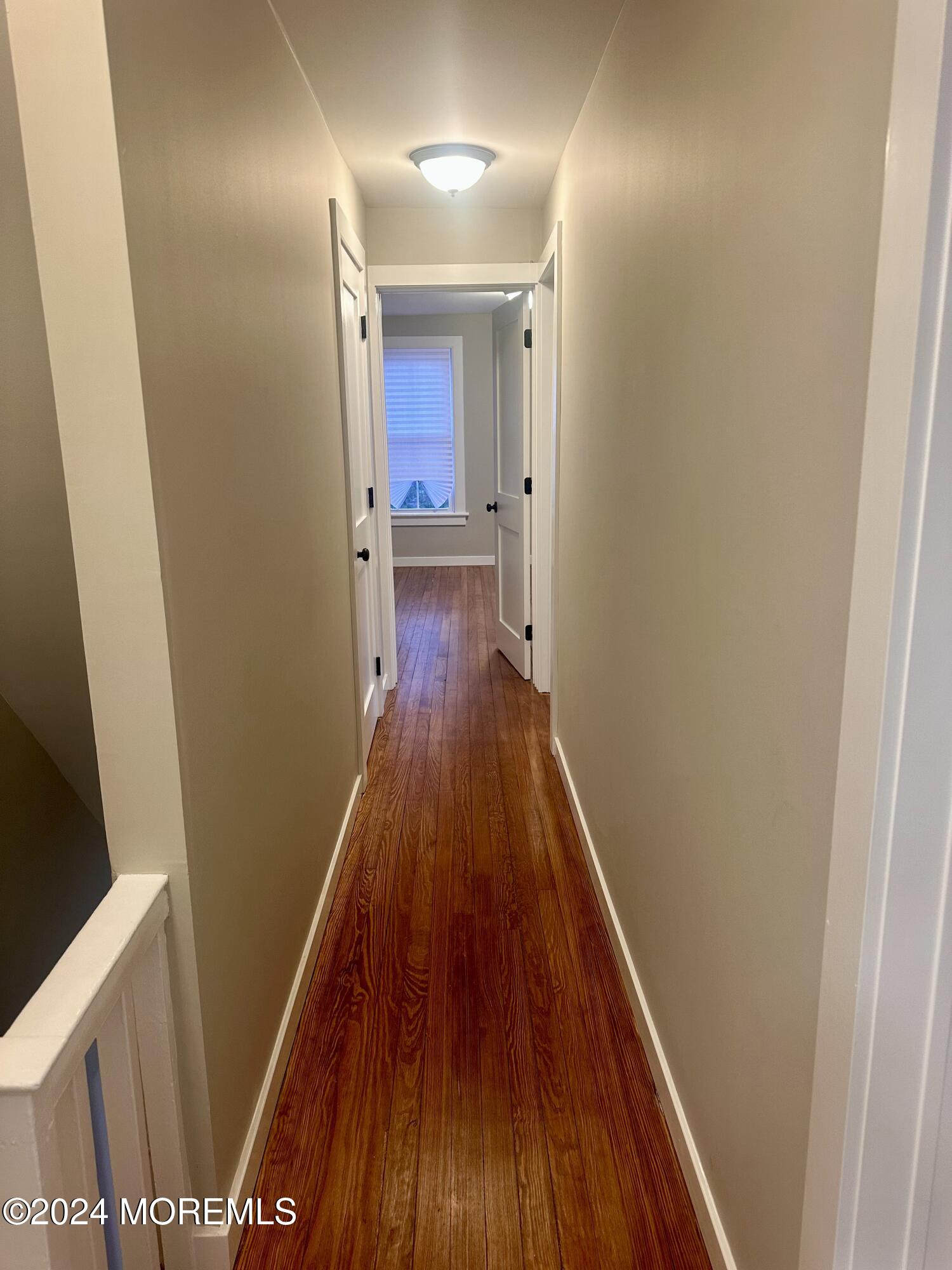 73 Church Street Manasquan, NJ 08736 - Photo 21 of 27 a view of a hallway with wooden floor and staircase