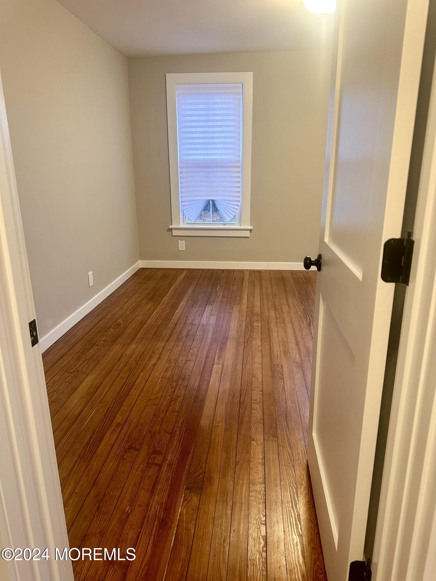 73 Church Street Manasquan, NJ 08736 - Photo 23 of 27 an empty room with wooden floor and windows