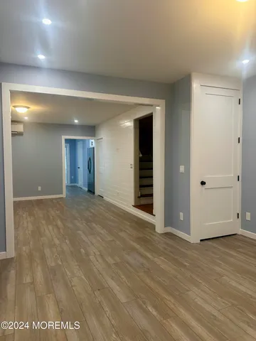a view of an empty room with wooden floor and closet
