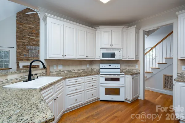 a kitchen with granite countertop a stove and a sink