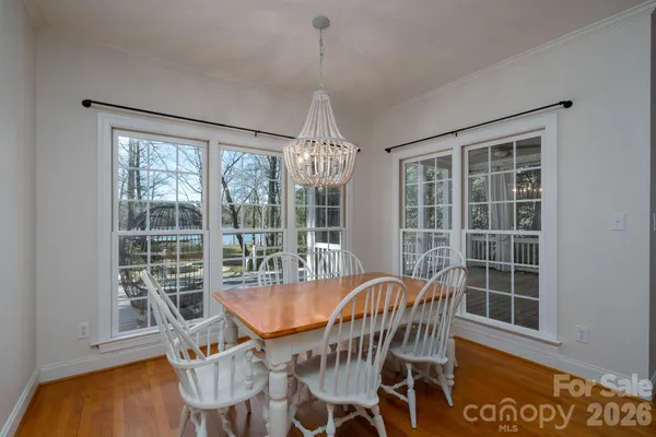 a dining room with furniture large windows and wooden floor