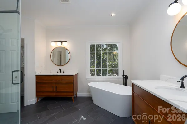a bathroom with a bathtub mirror and sink