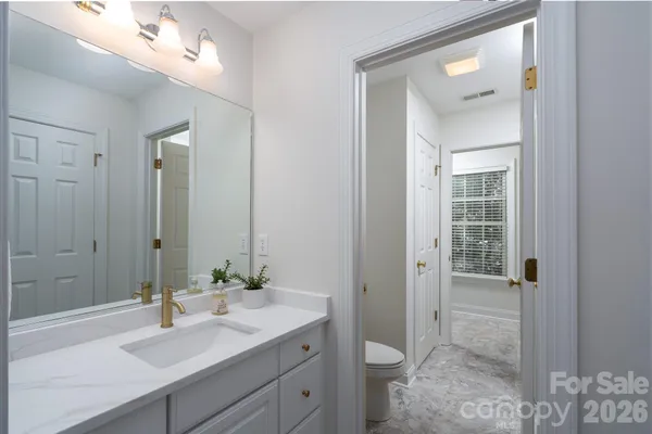 a bathroom with a sink vanity granite and toilet