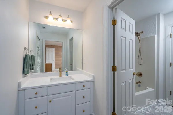 a bathroom with a double vanity sink mirror and bathtub