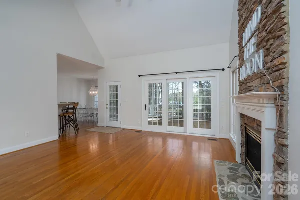 a view of a livingroom with wooden floor and a fireplace