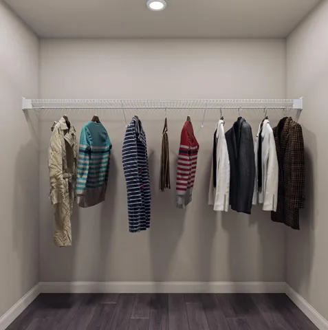 a view of walk in closet with clothes and shoes