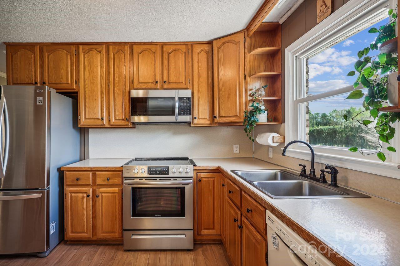 2362 Agony Acres Road Clover, SC 29710 - Photo 11 of 36 a kitchen with granite countertop a stove a sink and a microwave
