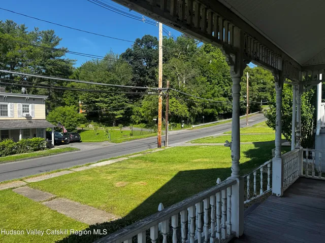 a view of a swimming pool with a porch and yard