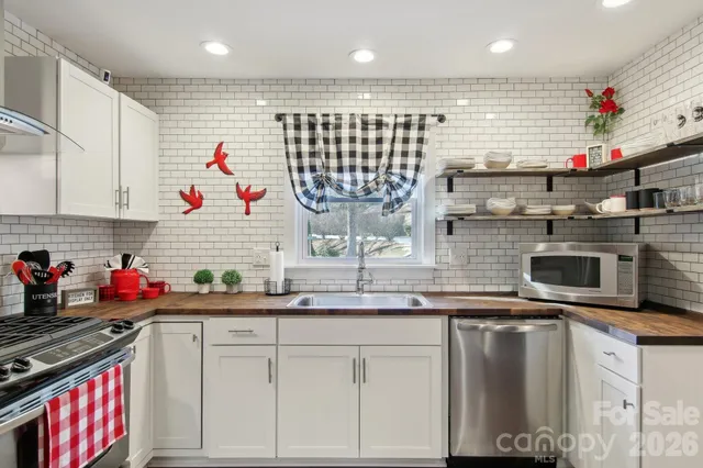 a kitchen with kitchen island granite countertop a sink stainless steel appliances and white cabinets