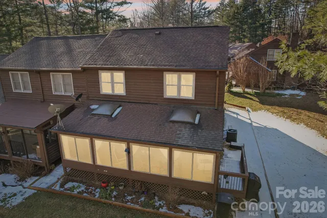 a view of a house with a small yard and large tree