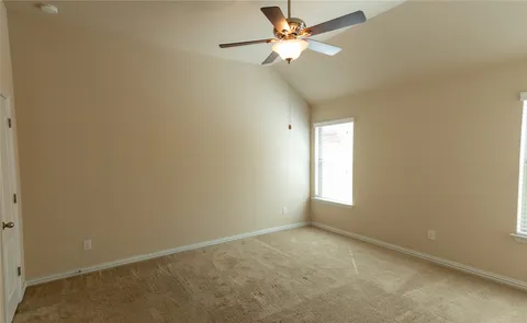 an empty room with a window and a fan