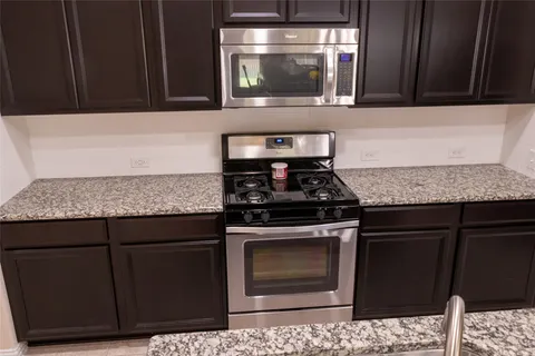 a kitchen with granite countertop cabinets and steel stove