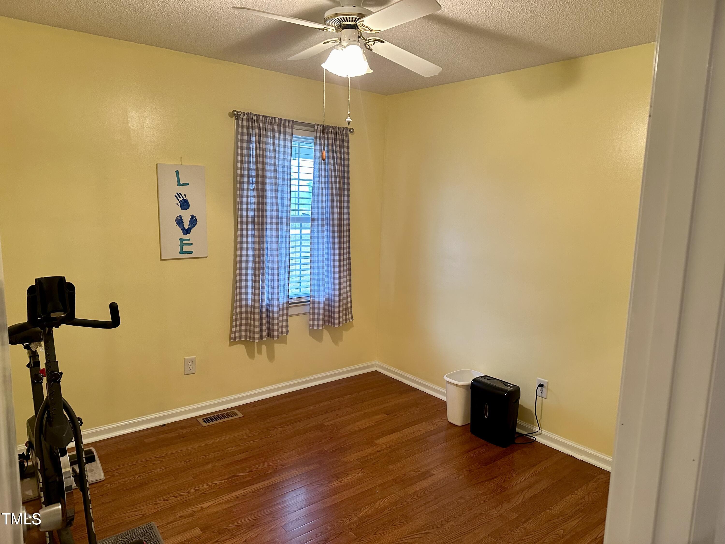 242 Edwards Road Henderson, NC 27537 - Photo 15 of 21 a view of empty room with wooden floor and fan