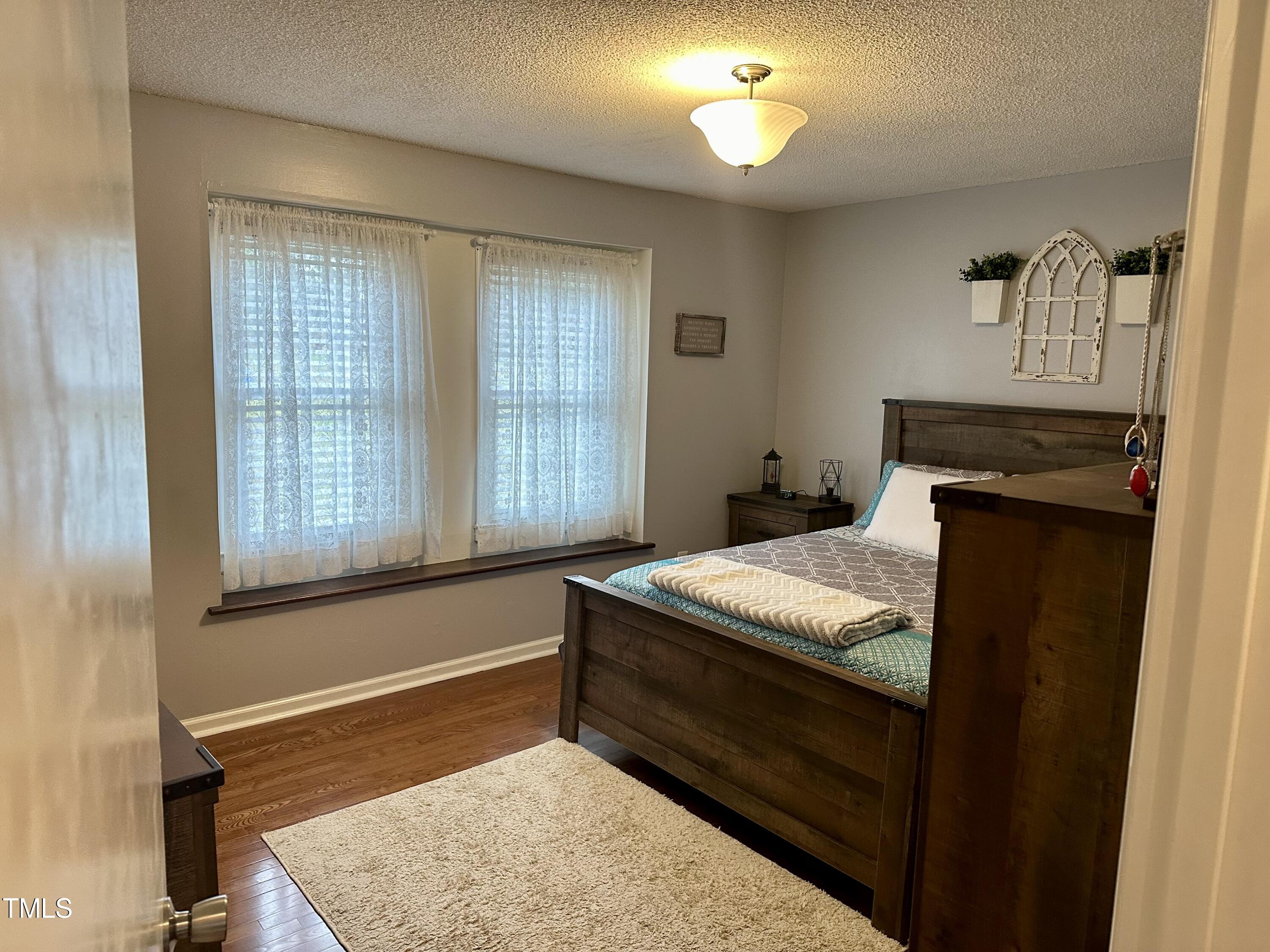 242 Edwards Road Henderson, NC 27537 - Photo 18 of 21 a bed sitting in a room next to a window
