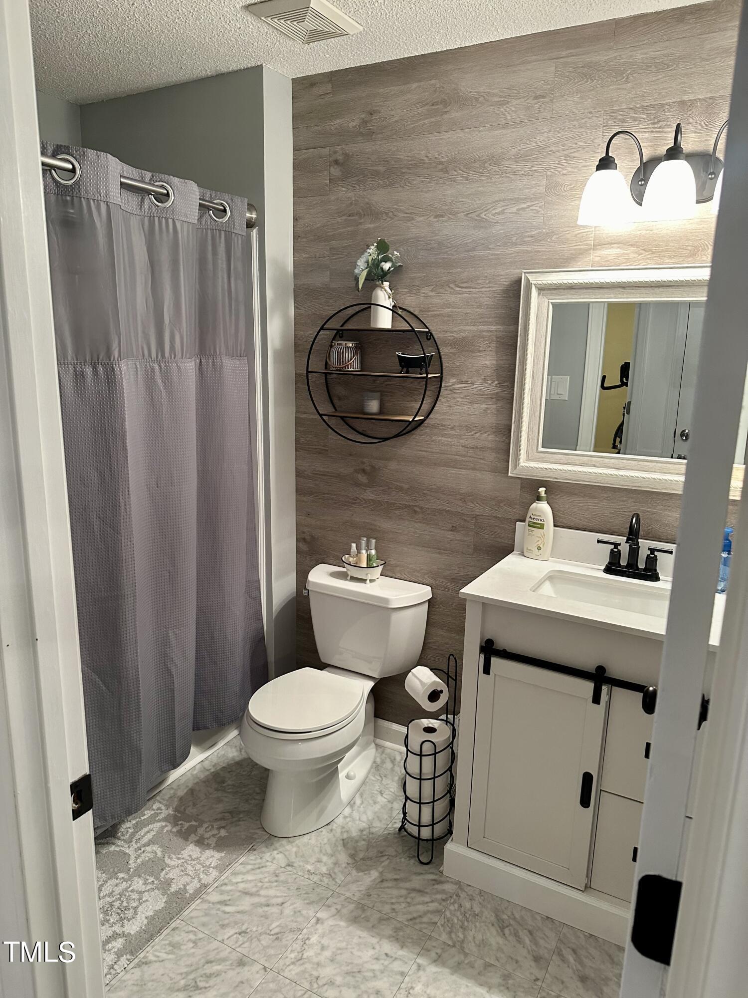 242 Edwards Road Henderson, NC 27537 - Photo 19 of 21 a bathroom with a sink toilet and a mirror