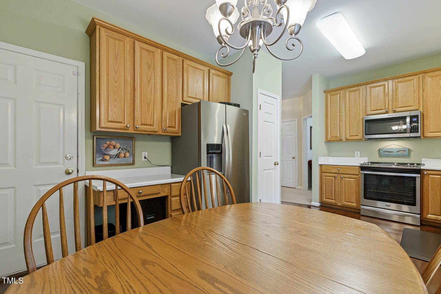 1001 Lake Moraine Place Raleigh, NC 27607 - Photo 17 of 37 a kitchen with stainless steel appliances a table chairs and microwave