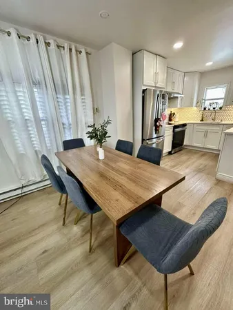 a kitchen with stainless steel appliances kitchen island granite countertop a table chairs and a refrigerator