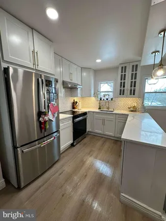 a kitchen with stainless steel appliances granite countertop a refrigerator a stove and a sink