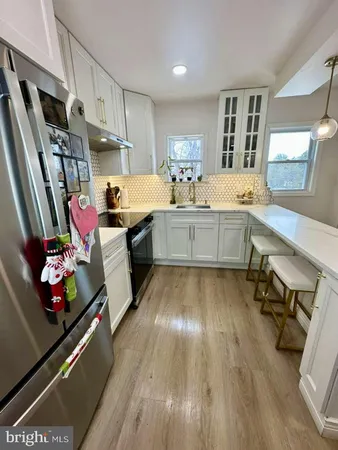 a kitchen with stainless steel appliances granite countertop a sink dishwasher stove top oven and refrigerator