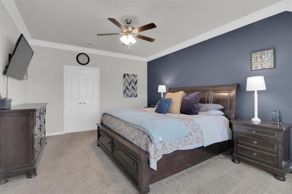 7818 Sagebrush Lane Godley, TX 76044 - Photo 17 of 38 a spacious bedroom with a bed and a chandelier