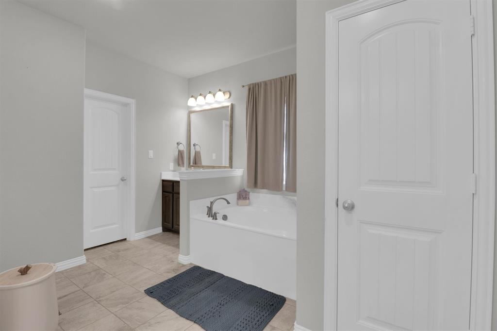 7818 Sagebrush Lane Godley, TX 76044 - Photo 22 of 38 a bathroom with a sink a tub and mirror