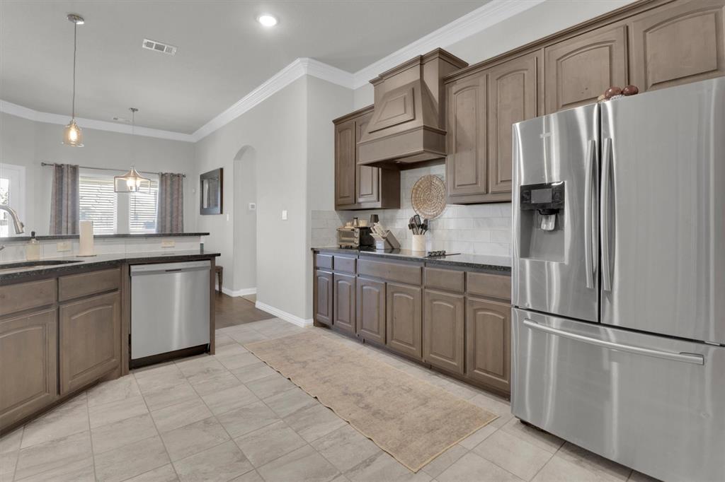 7818 Sagebrush Lane Godley, TX 76044 - Photo 7 of 38 a kitchen with granite countertop a refrigerator and a sink