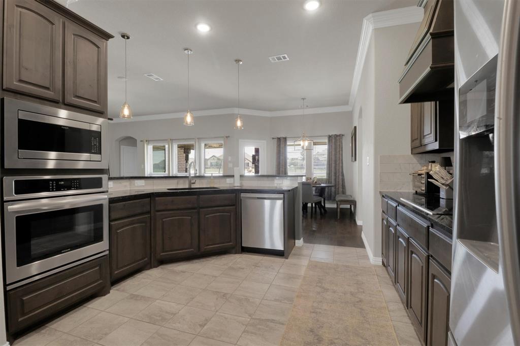 7818 Sagebrush Lane Godley, TX 76044 - Photo 8 of 38 a kitchen with stainless steel appliances kitchen island granite countertop a stove and a sink