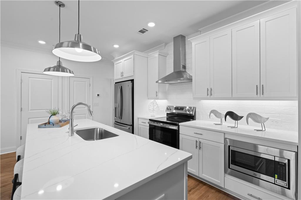 538 Alice Way, Unit D3 Cumming, GA 30040 - Photo 5 of 52 a kitchen with stainless steel appliances granite countertop a sink a stove a refrigerator and cabinets