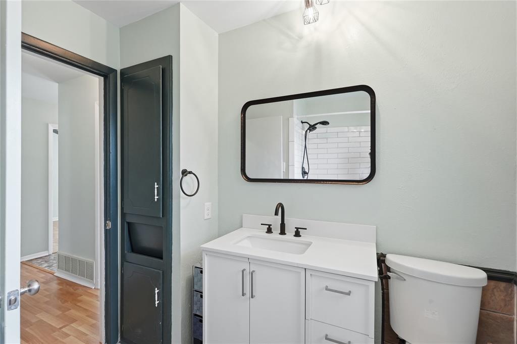 837 Springdale Road Bedford, TX 76021 - Photo 17 of 28 Bathroom vanity featuring a white countertop, undermount sink, and matte black faucet