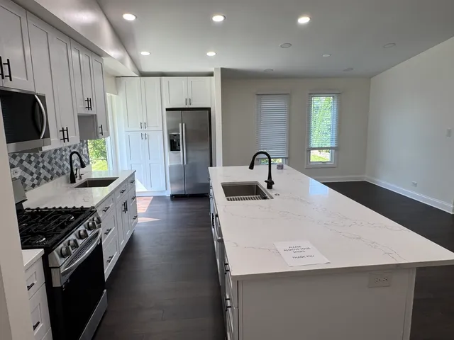 a kitchen with stainless steel appliances a sink stove and refrigerator